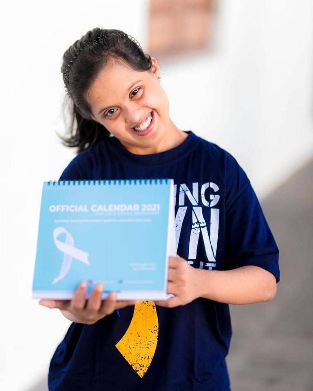 Holding the official One Stage calendar with a big smile