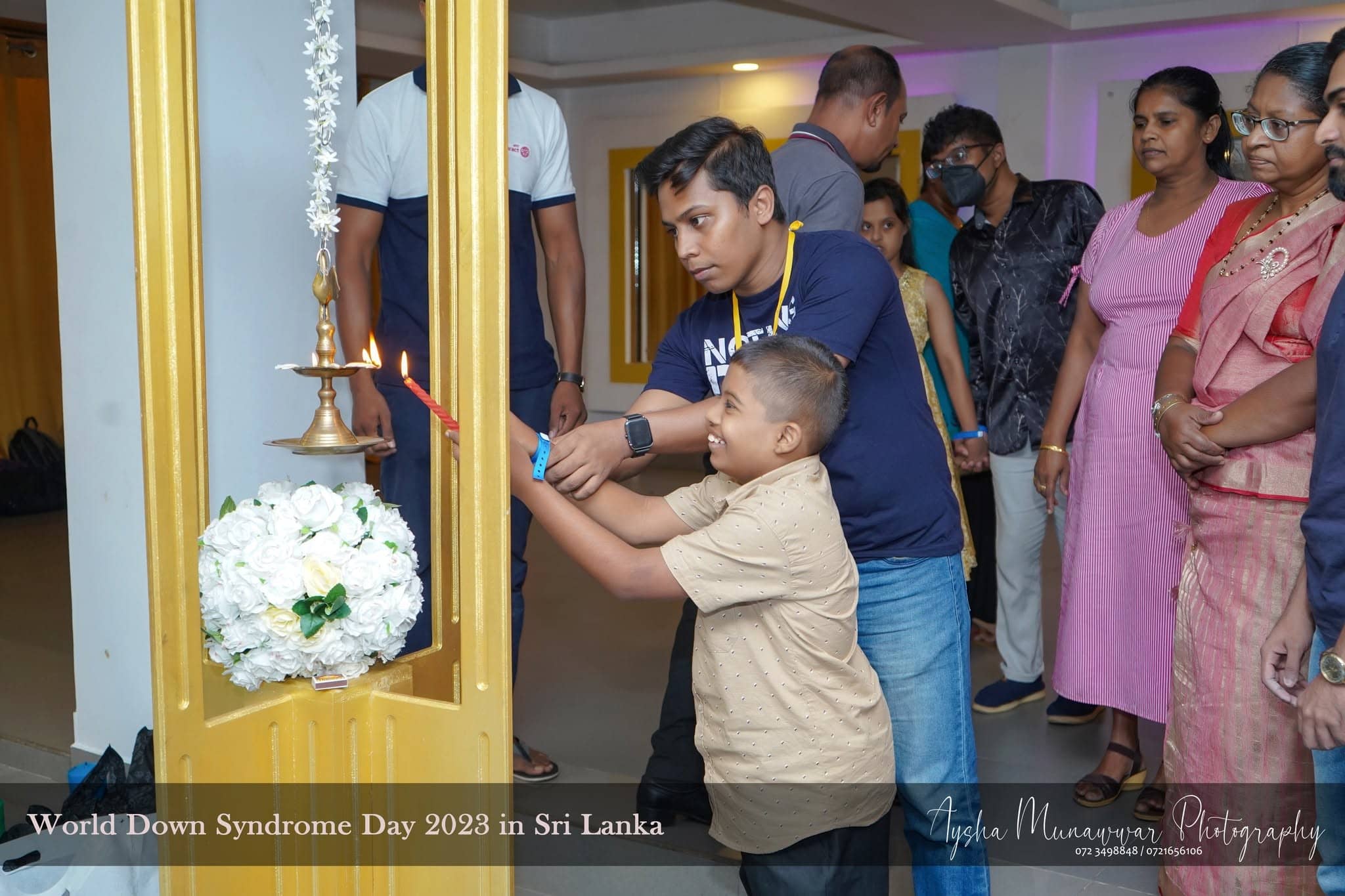 Helping hands light the oil lamp together at World Down Syndrome Day